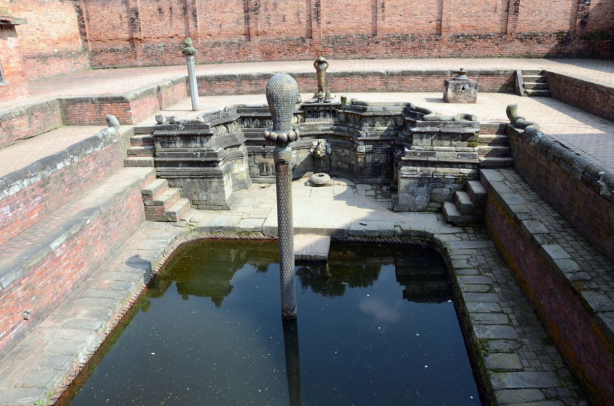 Kathmandu Bhaktapur 05-1 Bhaktapur Durbar Square Naga Pokhari The Naga Pokhari (Snake Pond) in the Palace of 55 Windows in Bhaktapurs Durbar Square is a 17C royal water tank encircled by a writhing stone cobra. The nagas rise up on scaled pillars.